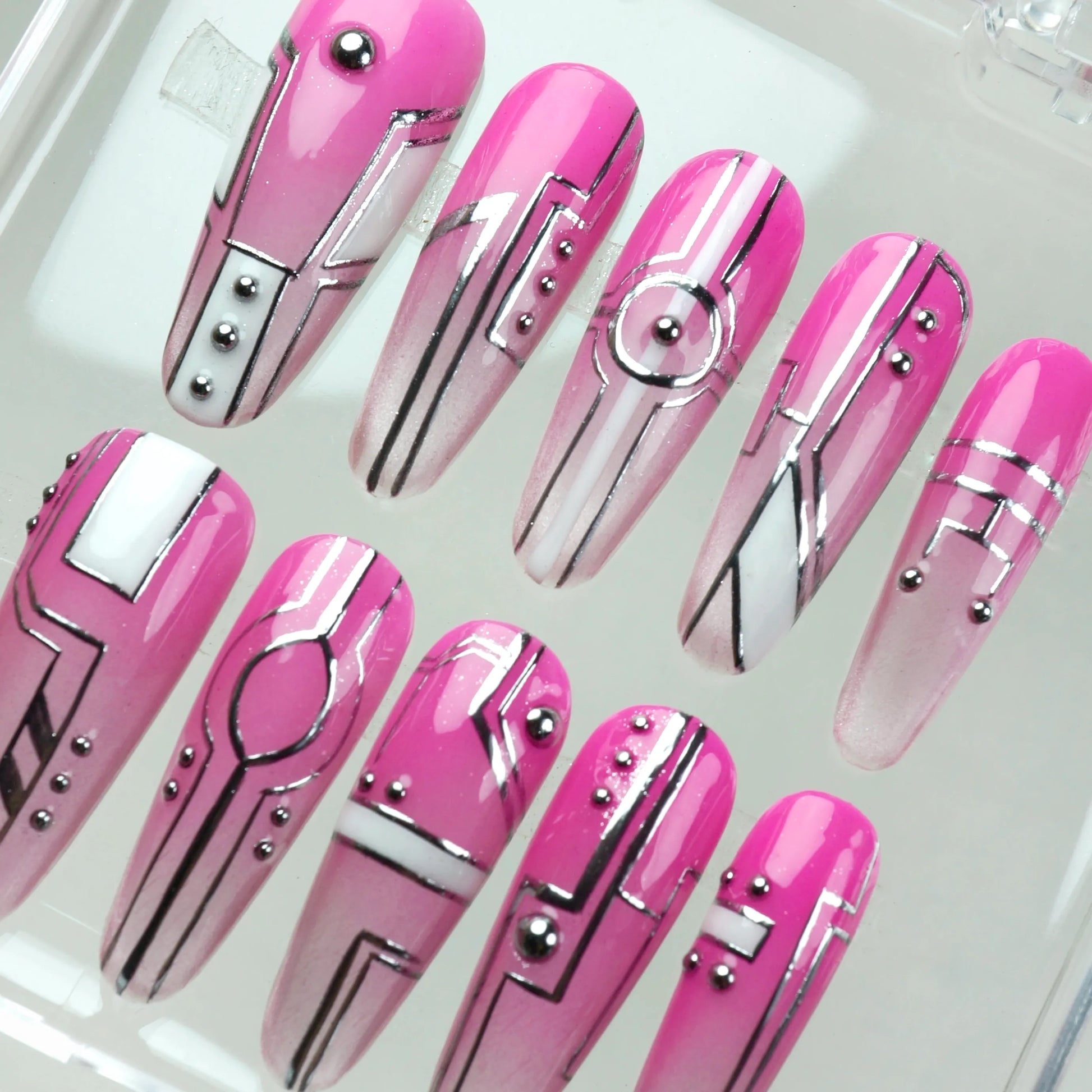 Edgy press-on nails with neon pink gradient, clean silver graphics, and futuristic layout elements