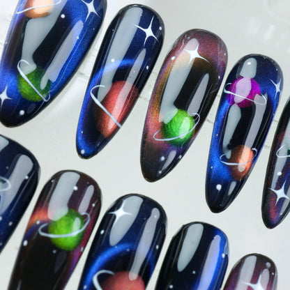Space-inspired press-on nails with multicolor planet designs, deep space ombré, and stardust sparkle