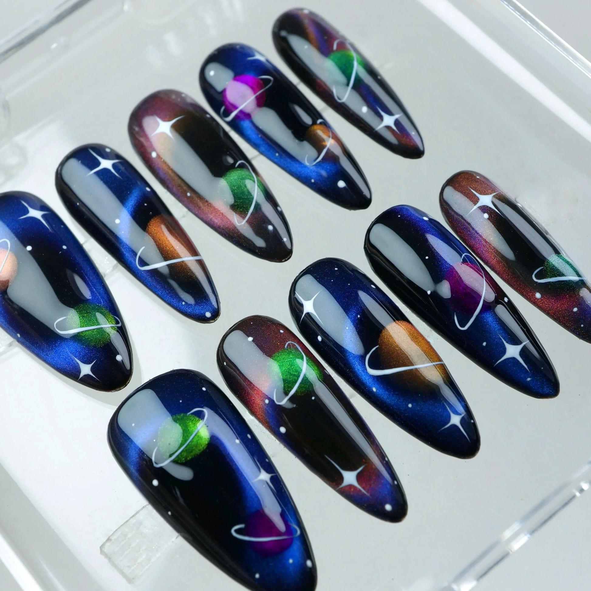 Press-on nails with hand-drawn planets, nebula hues, and a magical galaxy finish, perfect for celestial lovers