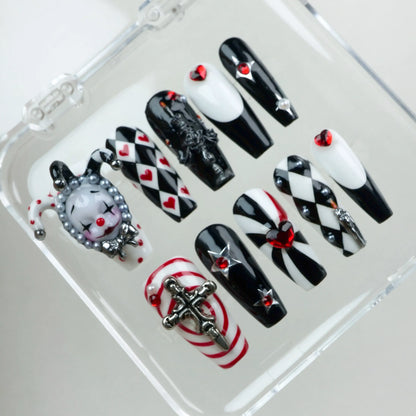 Bold black, white, and red press-on nails featuring jester motifs, gothic details, and heart embellishments from Donailsart.
