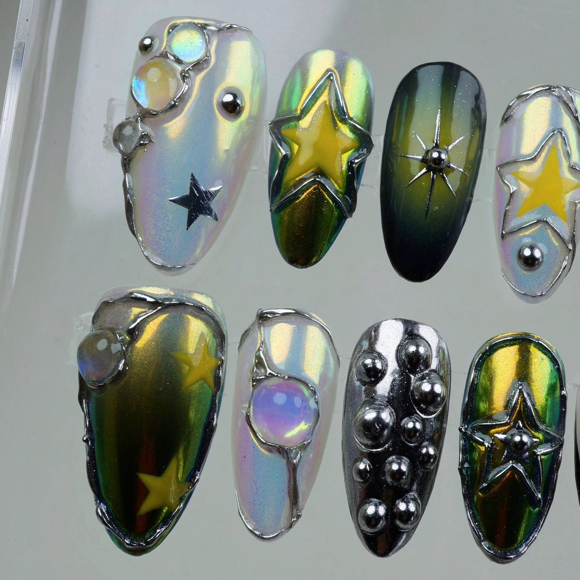 Galaxy-inspired press-on nails with chrome finish, 3D stars, celestial jewels, and holographic details.