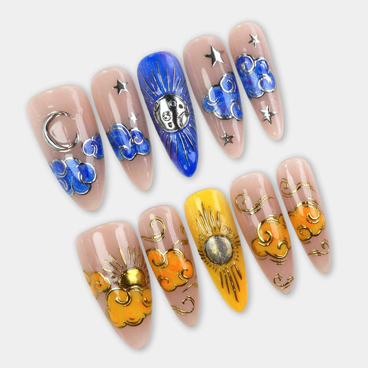 Press-on nails featuring celestial designs with the moon, sun, stars, and swirling blue and golden clouds on a nude base.