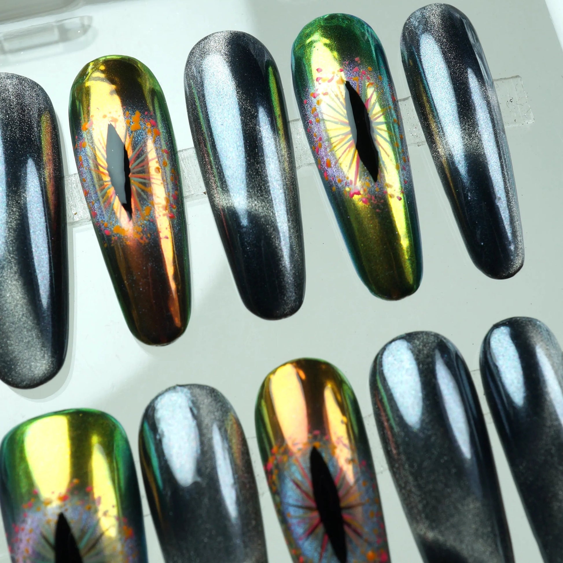 Fierce press-on nails with black shimmer and holographic snake-eye accents

