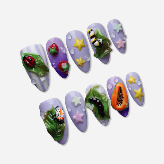 Garden Juice press-on nail set by Donailsart – pastel purple nails with 3D sculpted bugs, glossy leaves, fruit details, and dreamy star accents