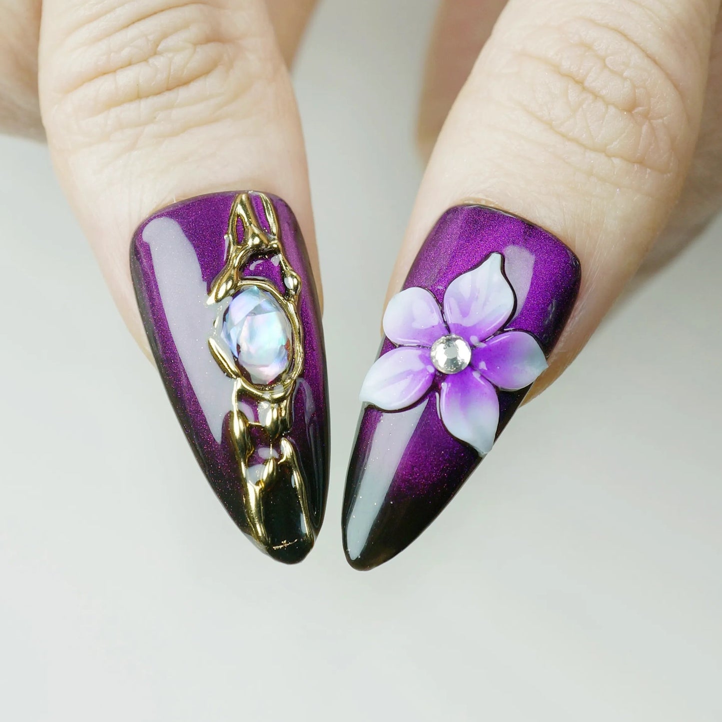 Veloria close-up detail showing sculpted violet blossom and iridescent stone accents on a deep amethyst and black gradient nail – Donailsart