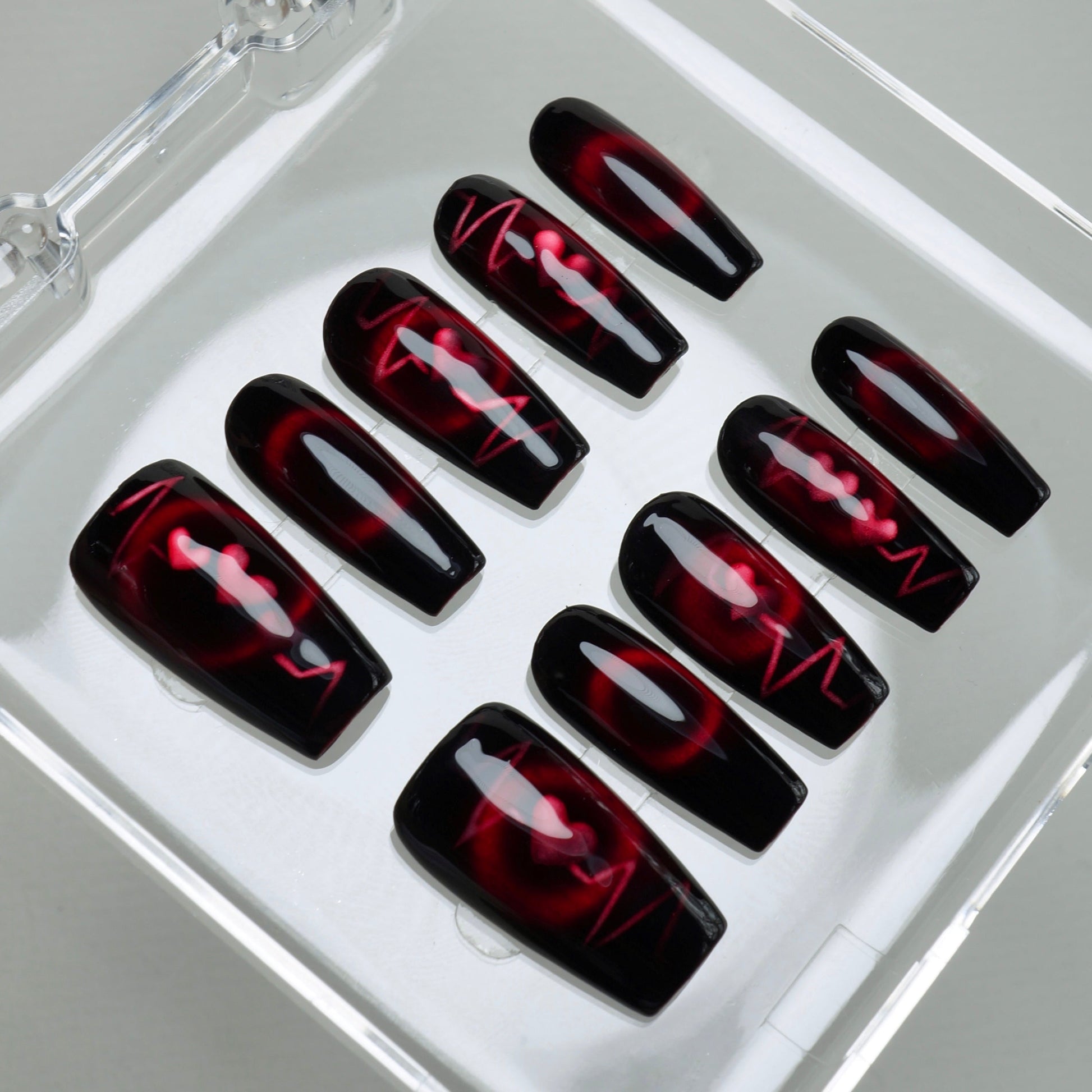 Set of black and red nail art designs in a clear case