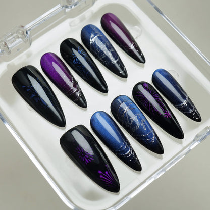 Galaxy-inspired press-on nails featuring blue shimmer, purple accents, and cat-eye firework effects.