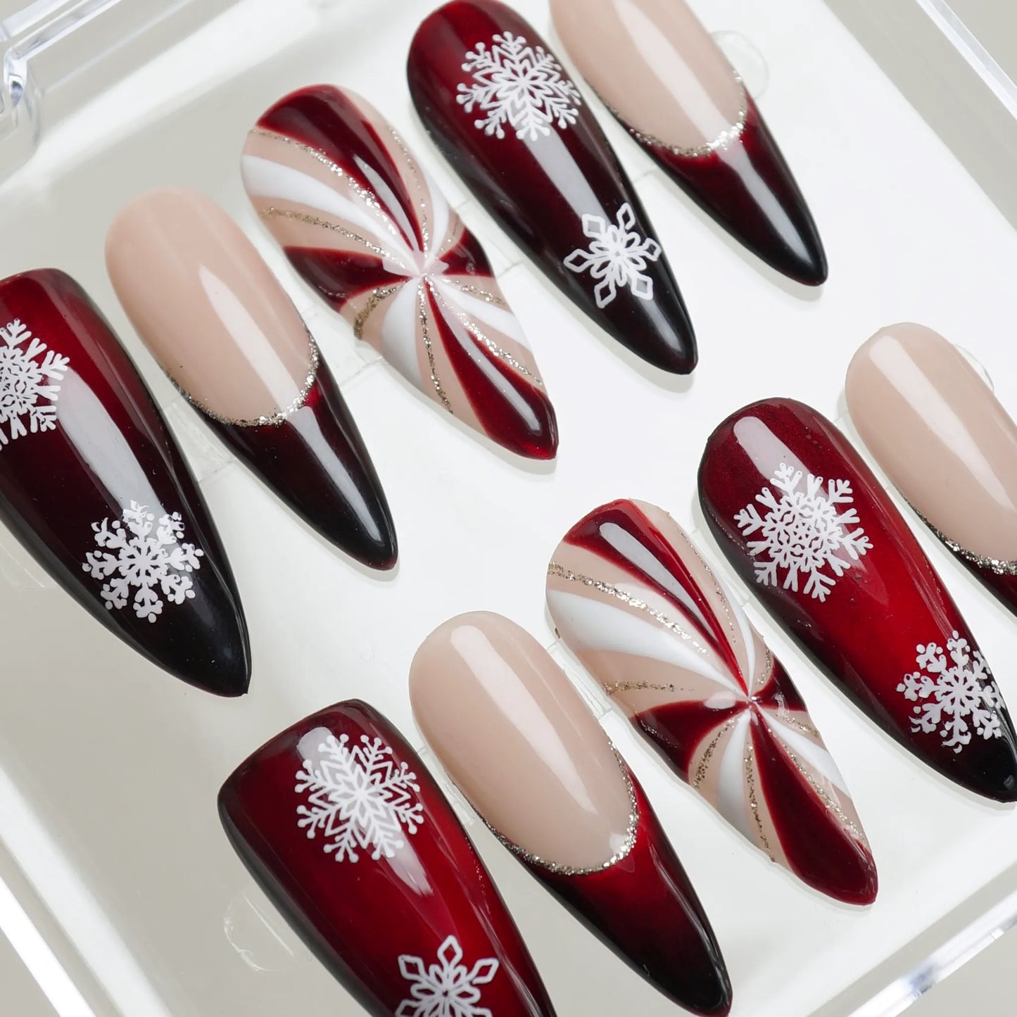 Christmas candy swirl nail set in red, white, and gold with detailed snowflake decorations Donailsart