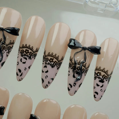 Noir Étreinte press-on nail set product view with boudoir-inspired nude, black lace, and satin bow nail art by Donailsart