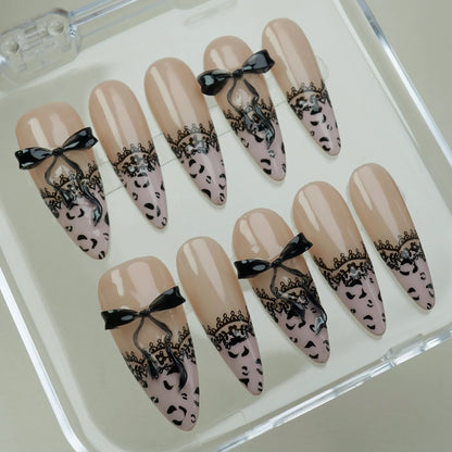 Noir Étreinte press-on nails on display showing the full nude and black lace bow nail art collection – Donailsart