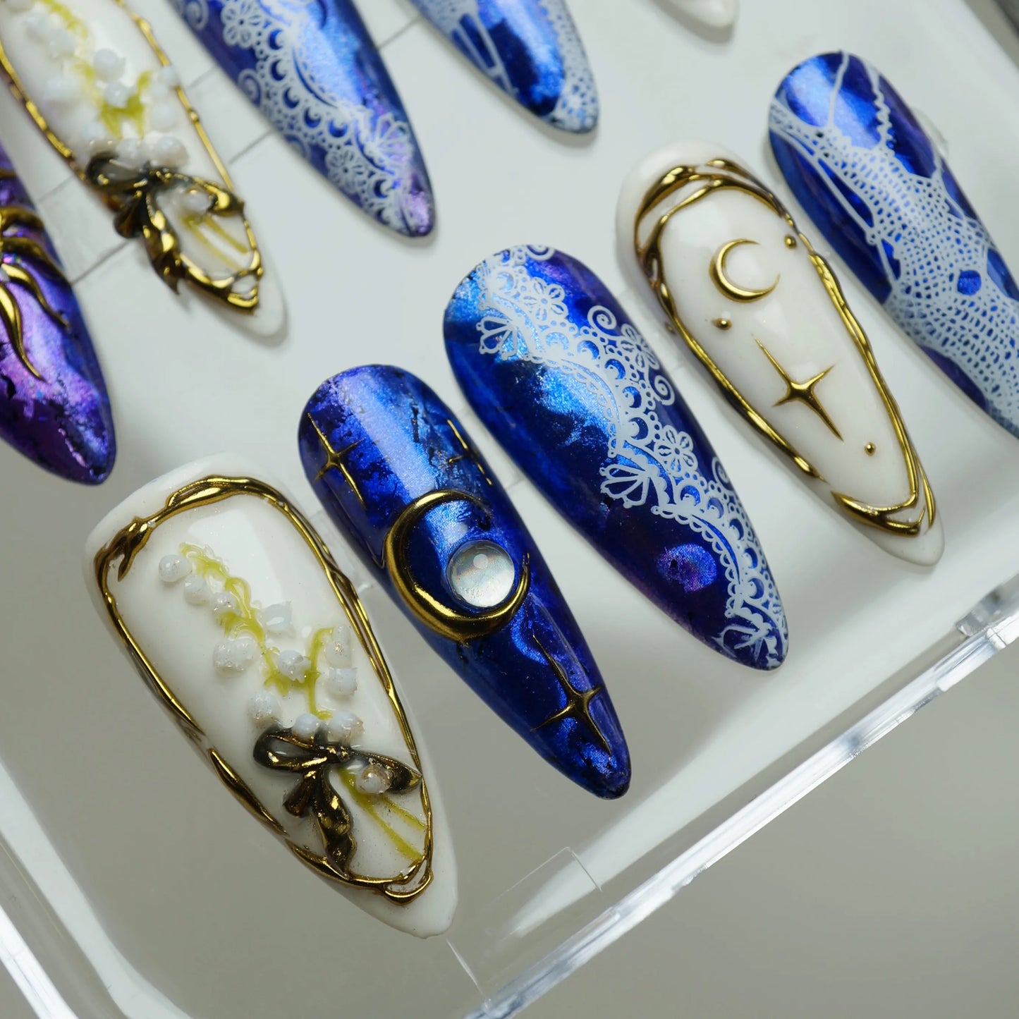 Celestine Sovereign close-up detail showing gold crescent moon and sun frame with white lace overlay on cobalt chrome nail – Donailsart