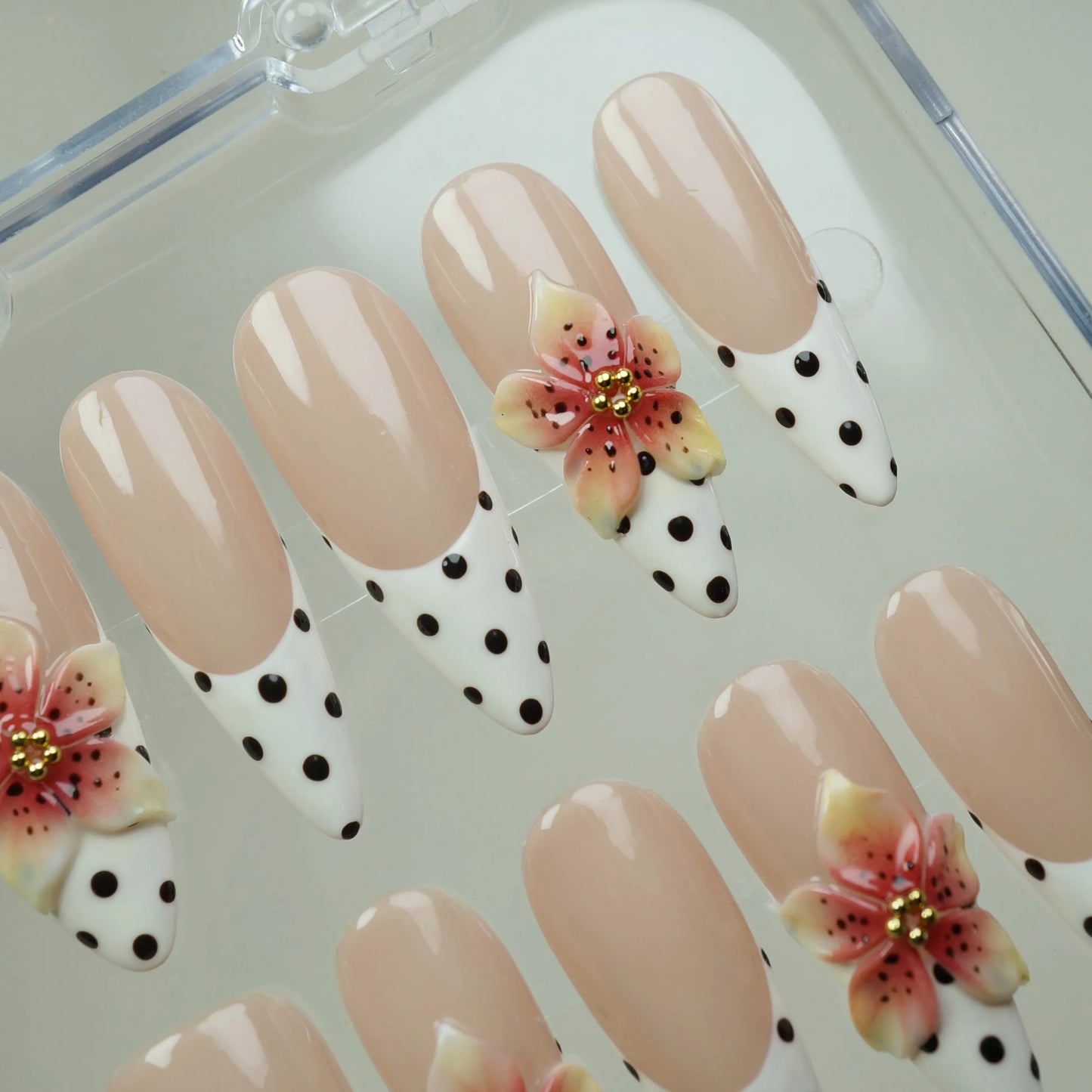 Petal Poise press-on nail set product view with charming nude, polka-dot French tip, and sculpted floral nail art by Donailsart