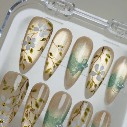 Orchard Veil press-on nail set product view with romantic champagne gold, white floral vine, and mint ribbon nail art by Donailsart