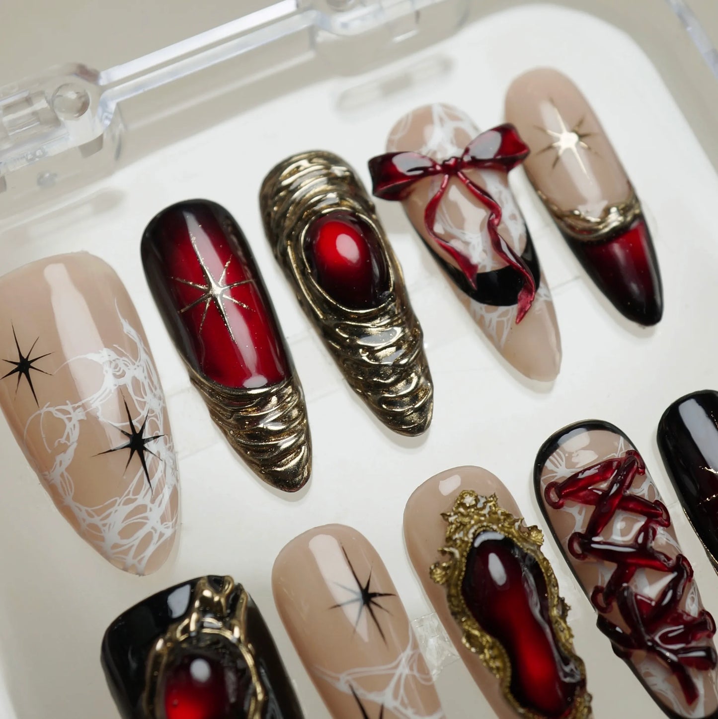 Royal Ruin press-on nails on display showing the full dark crimson chrome and gold corset nail art collection – Donailsart