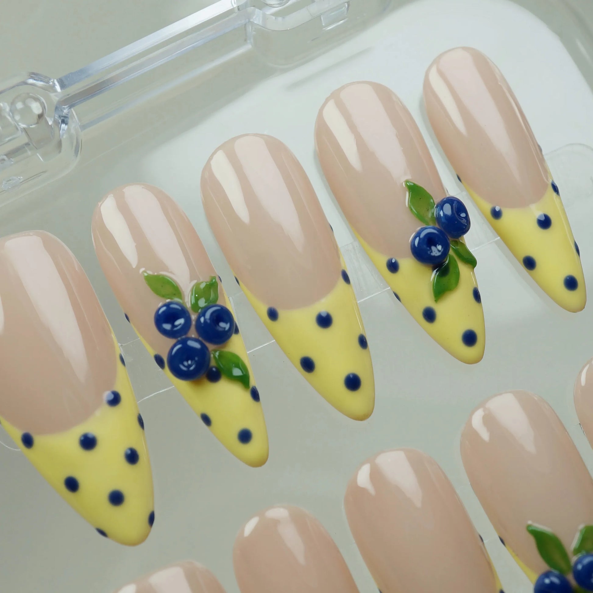 Solar Berries nail art detail view featuring sunny yellow French tips and blue polka dot designs on nude nails – Donailsart
