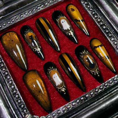 Amber Haunt press-on nails, angled close-up of gold cameo Halloween frames