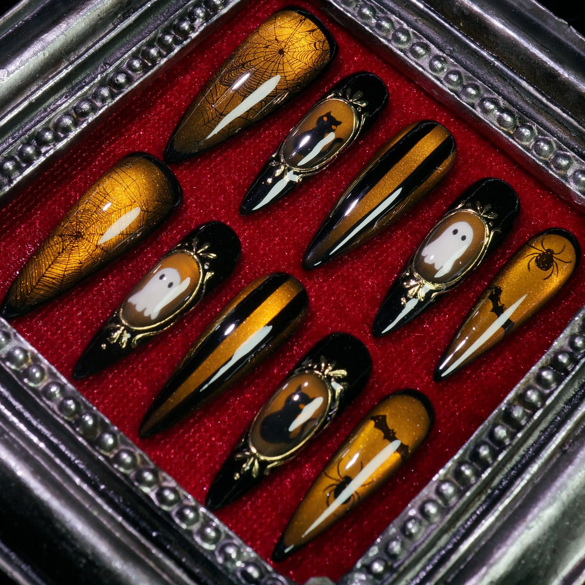 Amber Haunt press-on nails, close-up of gold cameo Halloween frames