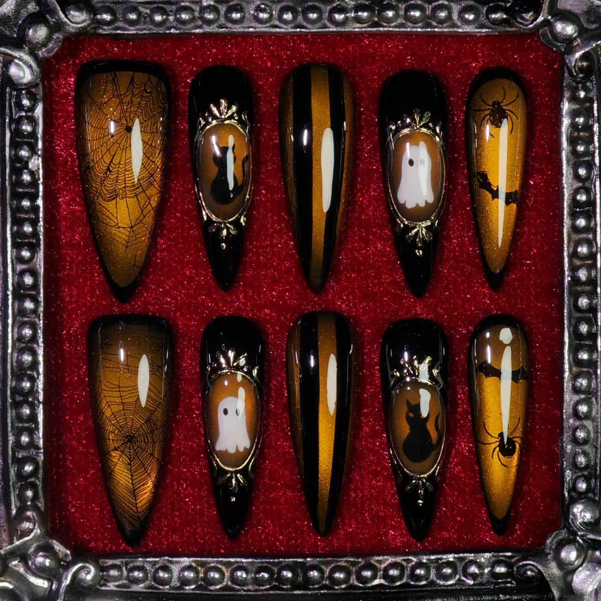Amber Haunt press-on nails: amber-gold cat-eye nails with gold cameo frames of a ghost, black cat, bat and spider