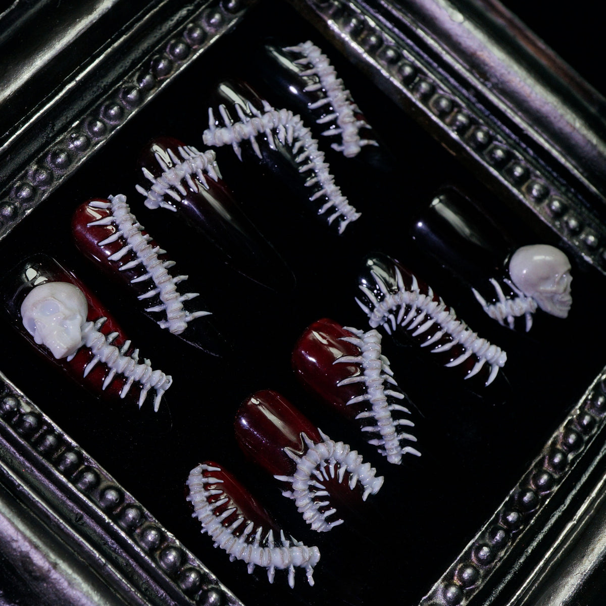 Human Centipede press-on nails, close-up of 3D bone spines and skulls