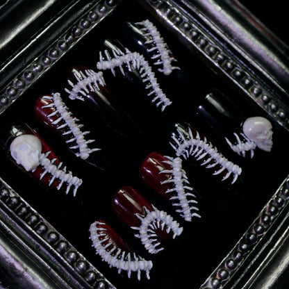 Human Centipede press-on nails, close-up of 3D bone spines and skulls