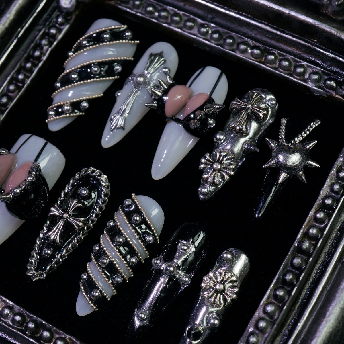 Metallic Crush press-on nails, close-up of silver chains, studs and bows
