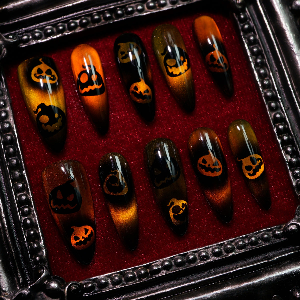 Pumpkin Curse press-on nails, angled close-up of jack-o'-lantern faces