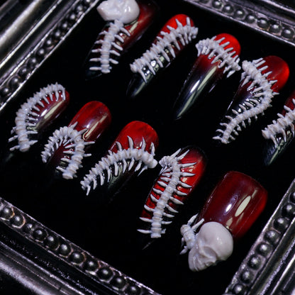 Human Centipede press-on nails, angled close-up of 3D bone spines and skulls