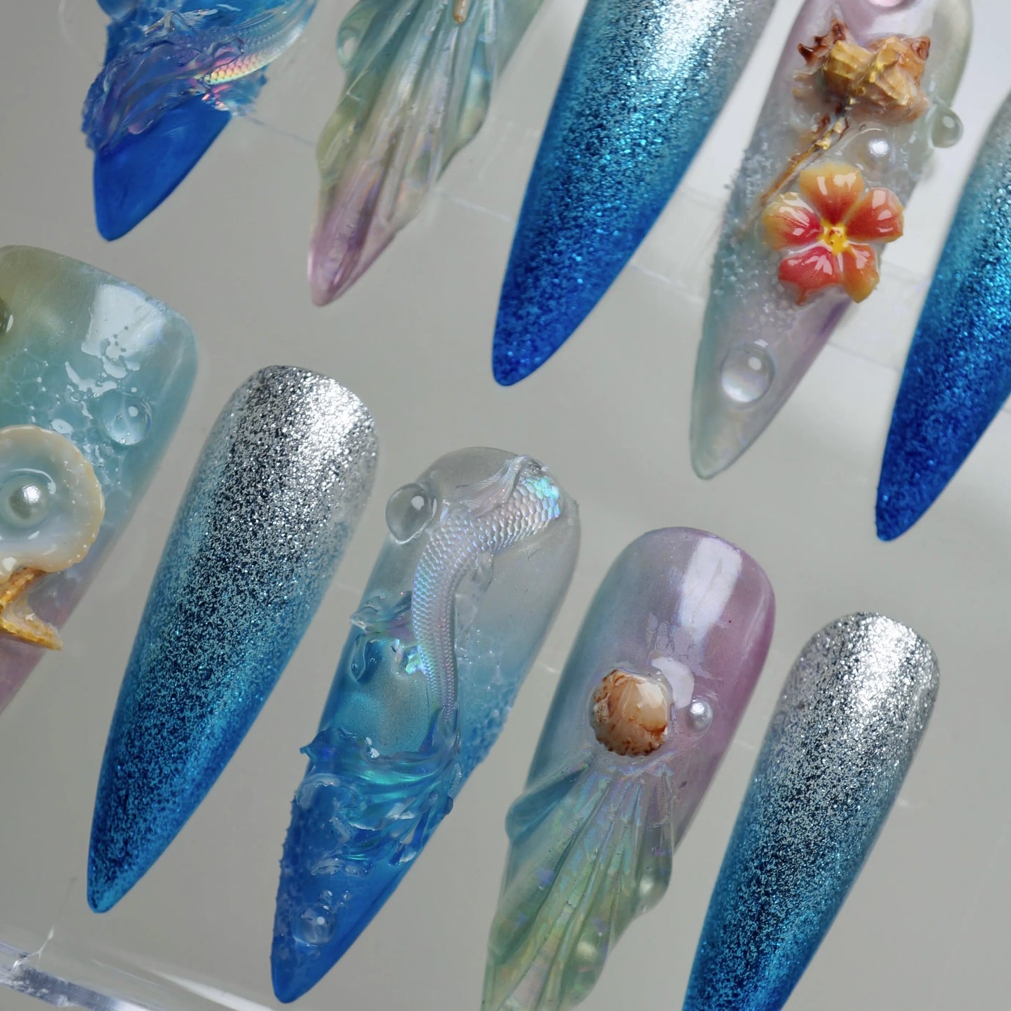 Aqualume close-up detail showing translucent iridescent layers and sculpted sea element detail on a light-shifting nail – Donailsart