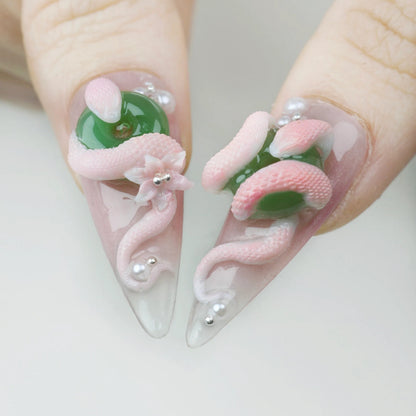 Nails with pink and green design on a white background