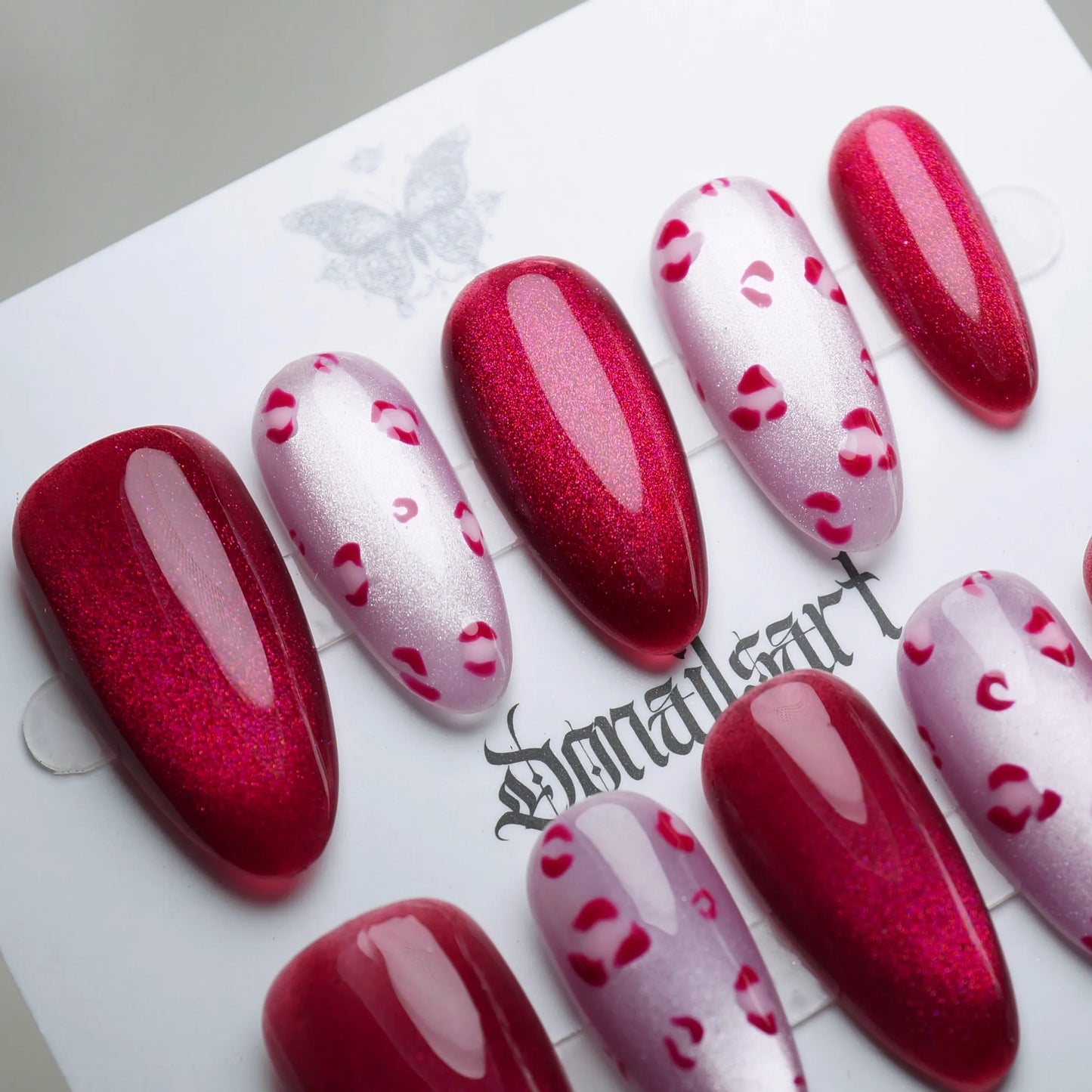 B8 | Sugar Kisses close-up detail showing glossy red shimmer with subtle leopard print accents on soft pink nails – Donailsart