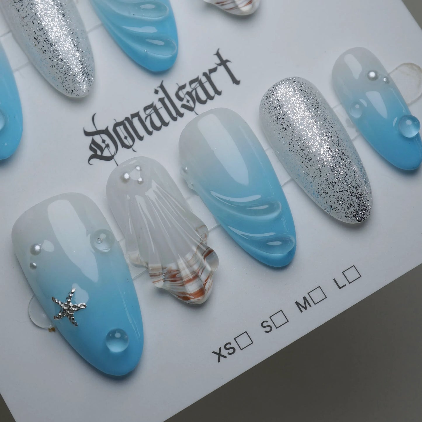 A30 | Blue Lagoon press-on nail set product view with serene soft blue ocean gradient, shell, and shimmer nail art by Donailsart