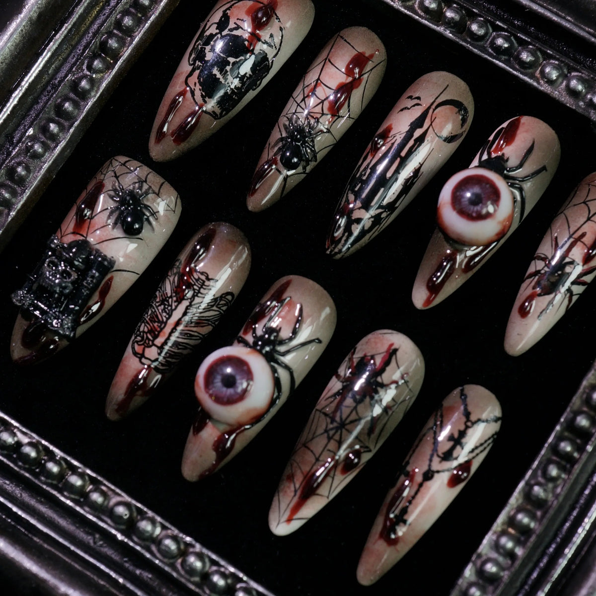 Creeping Gaze press-on nails, angled close-up of 3D eyeballs and skulls