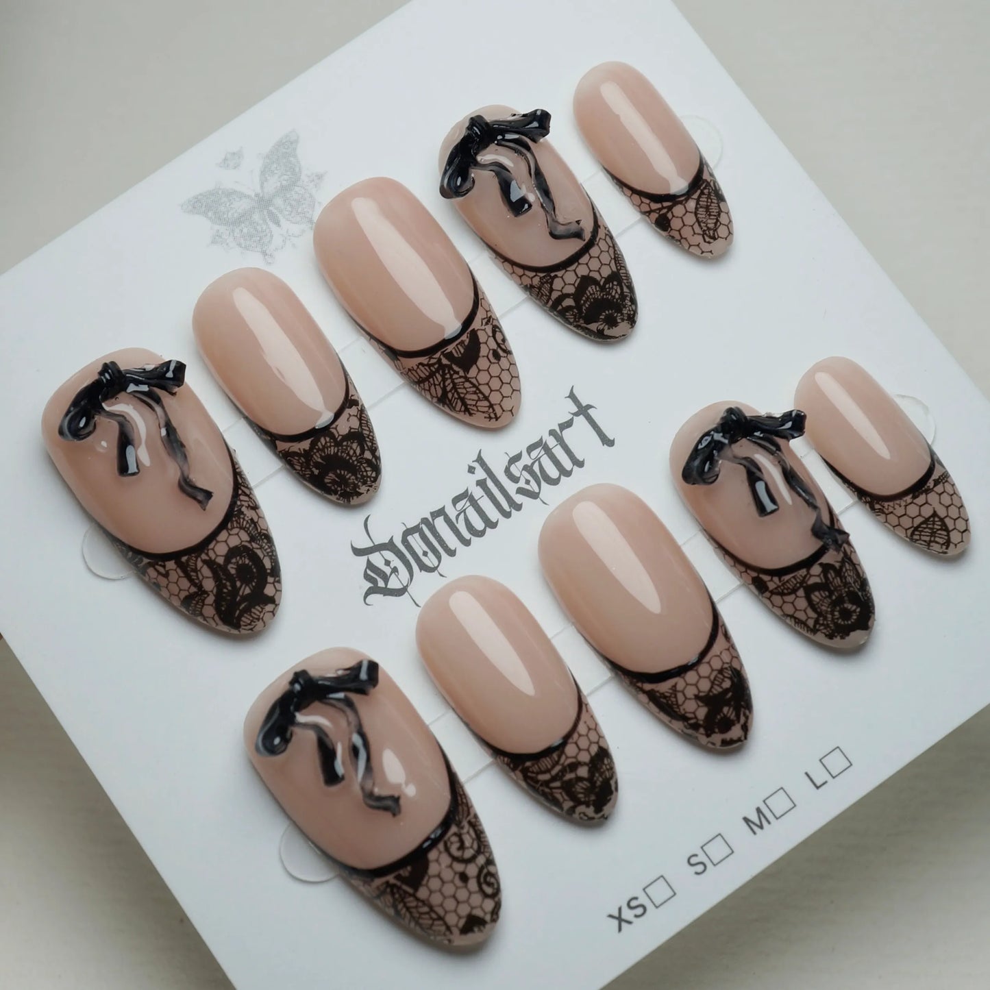 B4 | Sexy Lady press-on nails on display showing the full sheer nude and black lace nail art collection – Donailsart