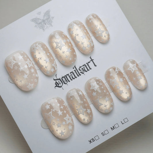 B5 | Ivory Lumen press-on nails on display showing the full sheer ivory and gold shimmer nail art collection – Donailsart