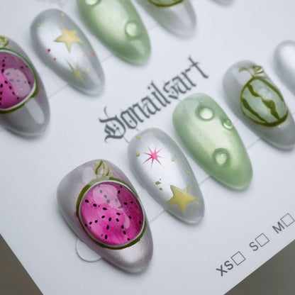 A26 | Melon Mirage close-up detail showing surreal fruit illustration and star accents on chrome silver reflective nails – Donailsart