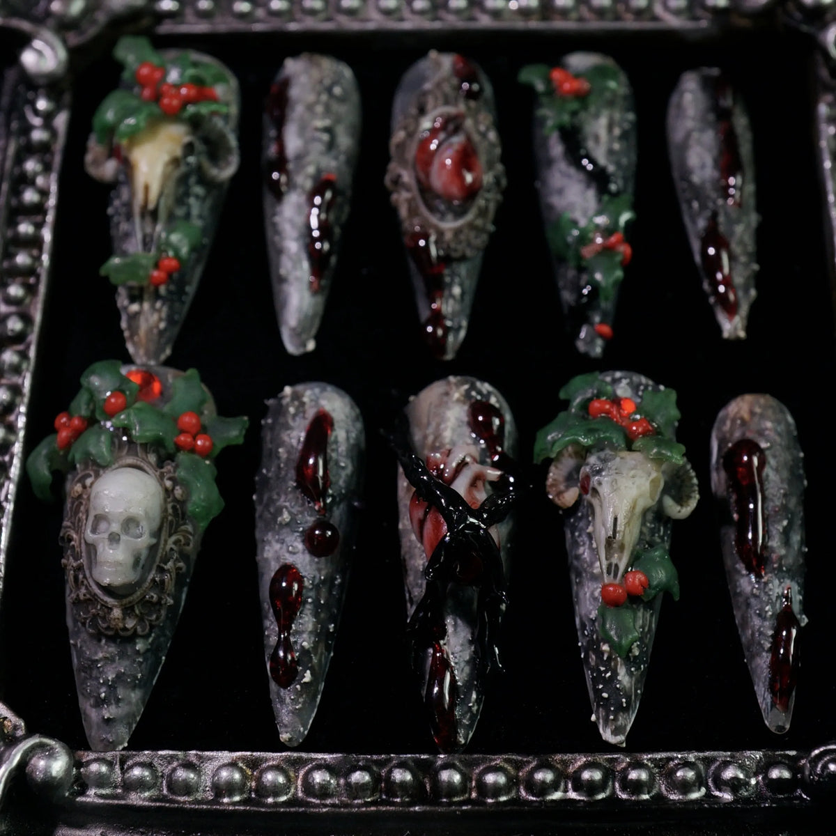 Baphomet x Christmas press-on nails, angled close-up of occult goat skulls and holly