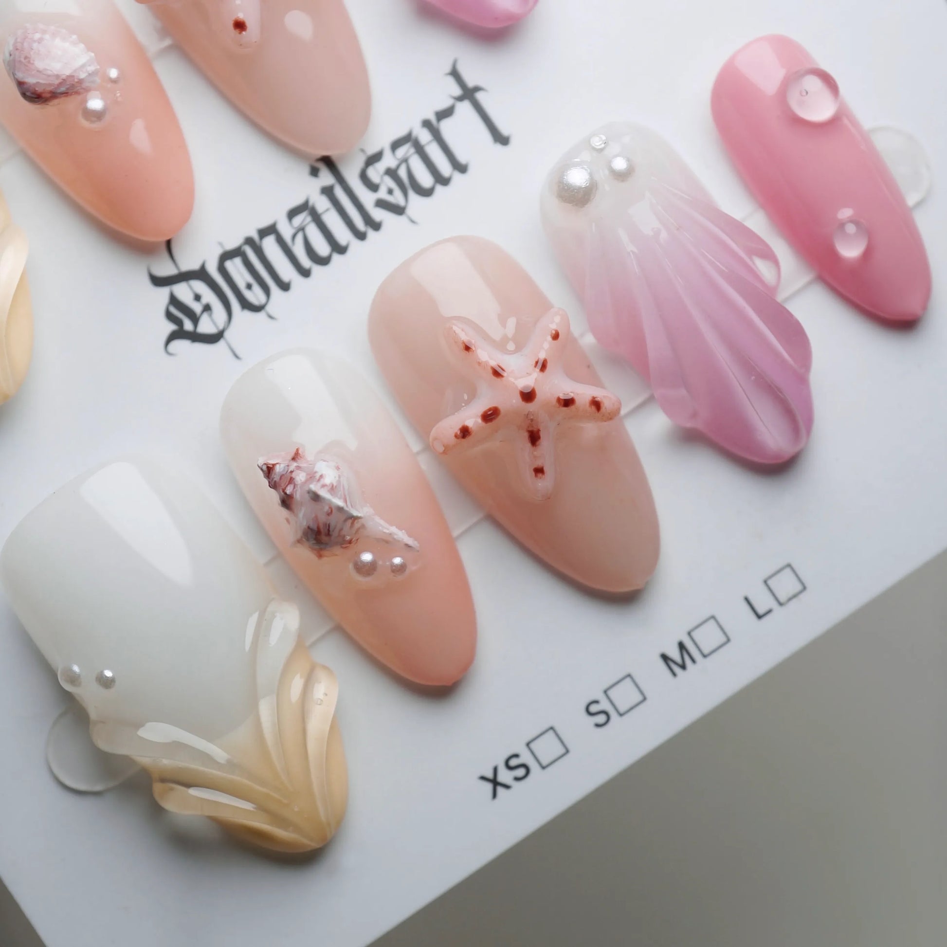 A27 | Pink Taffy Tide press-on nail set product view with soft pink peach beach and shell nail art by Donailsart