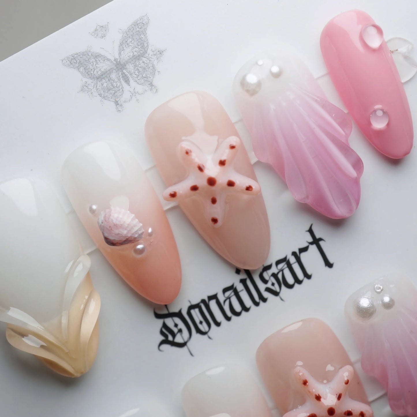 A27 | Pink Taffy Tide close-up detail showing sculpted shell and starfish accents on creamy pink and peach nails – Donailsart