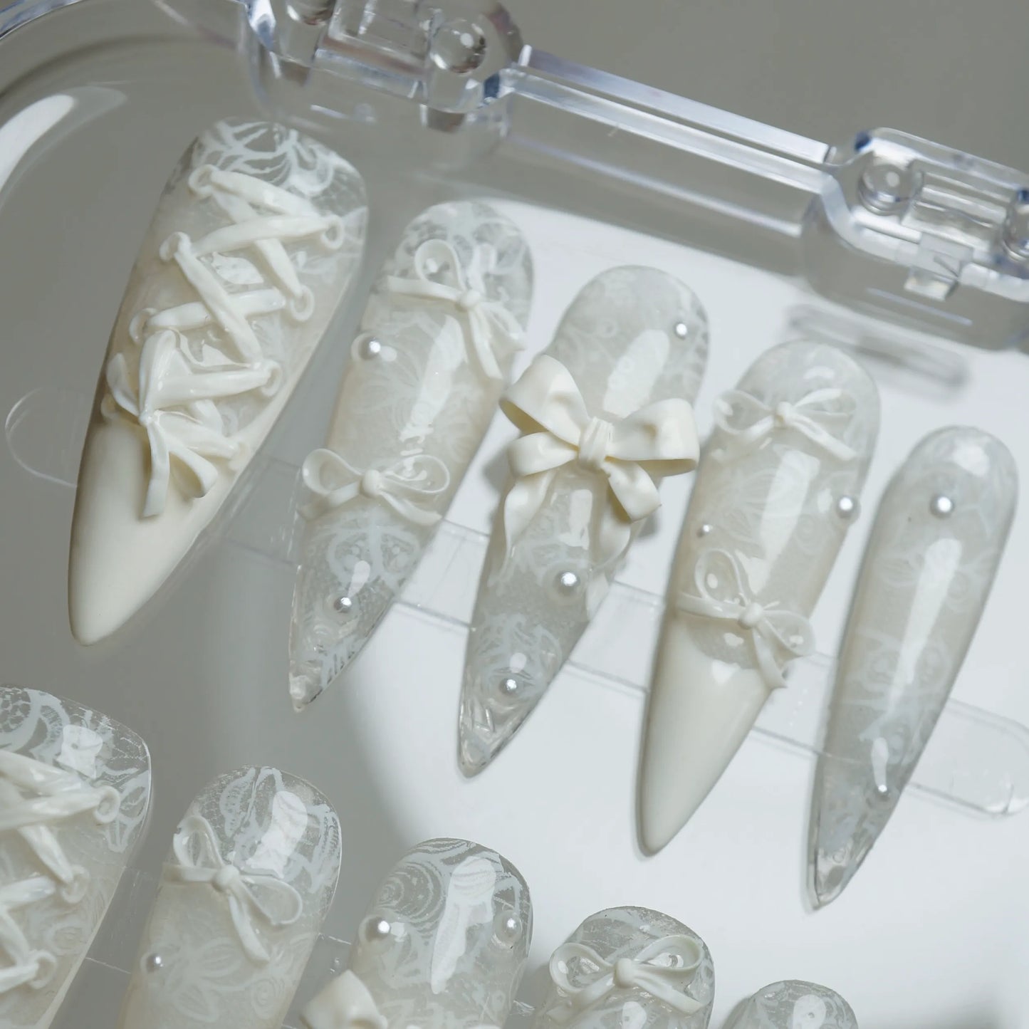 Ivory Keepsake press-on nails on display showing the full elegant lace and bow nail art collection – Donailsart