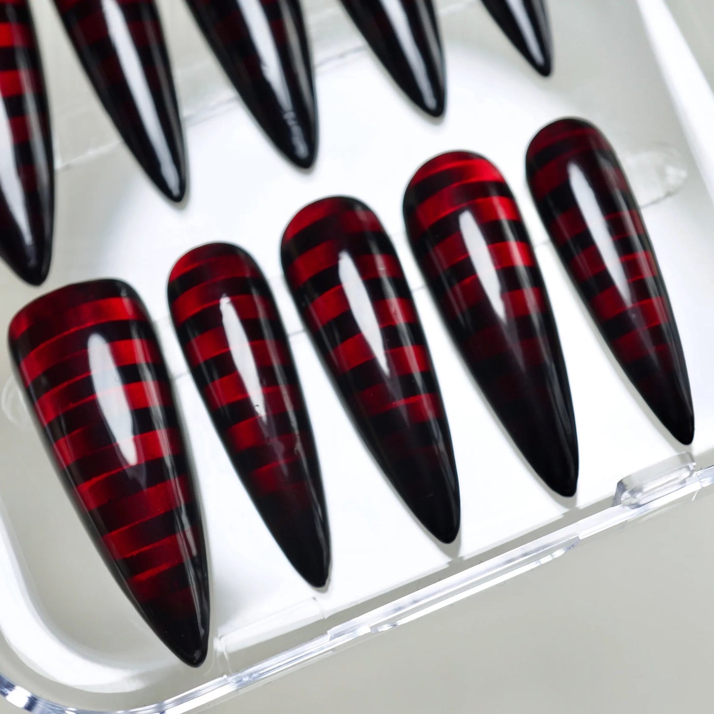 Riot Grid close-up detail showing crimson translucent grid lines glowing beneath glossy black nail surface – Donailsart