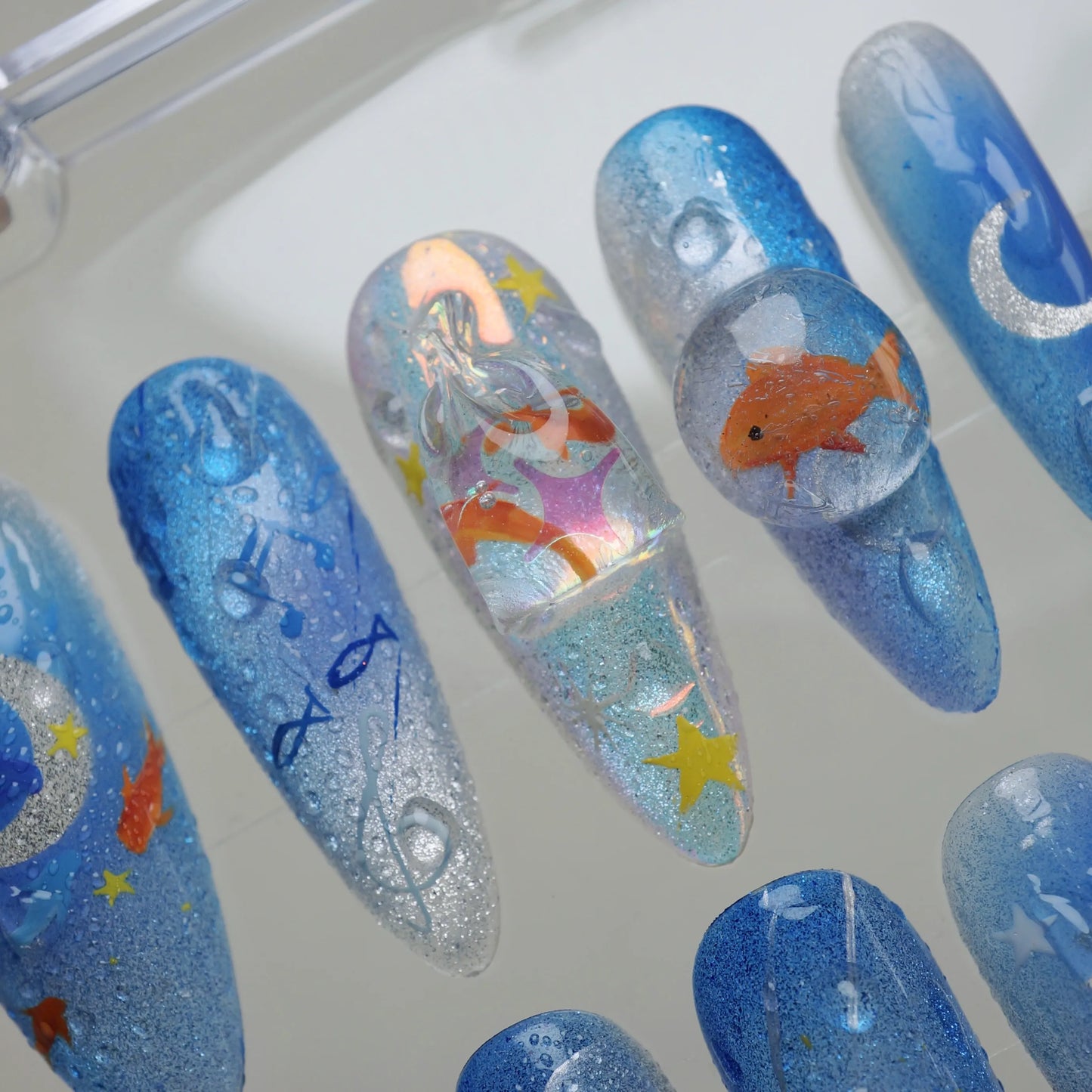Starlit Aquarium close-up detail showing floating goldfish, silver moon, and holographic shimmer in a layered glassy nail finish – Donailsart