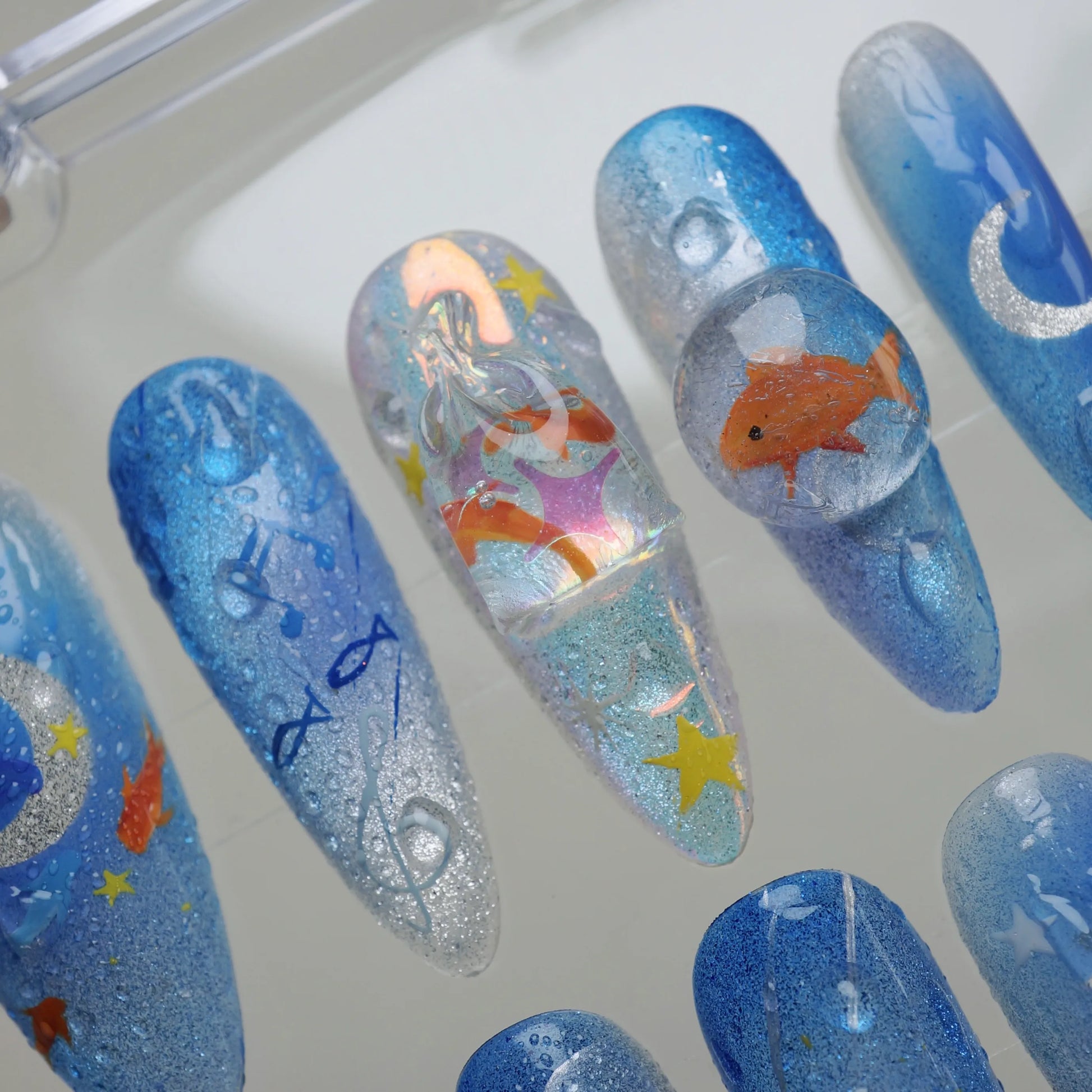 Starlit Aquarium close-up detail showing floating goldfish, silver moon, and holographic shimmer in a layered glassy nail finish – Donailsart