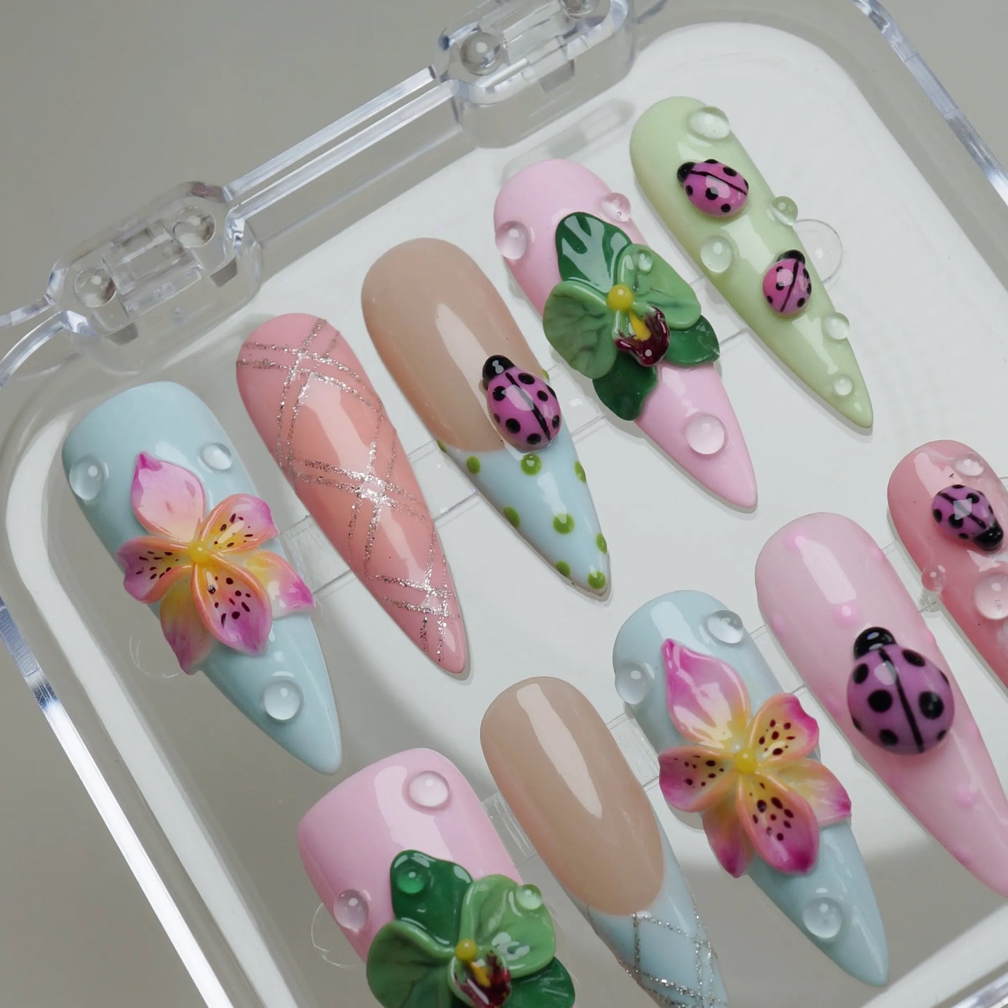 Ladybug Lagoon press-on nail set product view with dreamy garden scene nail art featuring ladybugs and blooming petals by Donailsart