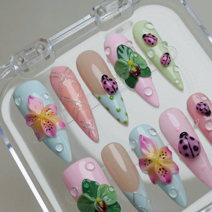 Ladybug Lagoon press-on nail set product view with dreamy garden scene nail art featuring ladybugs and blooming petals by Donailsart