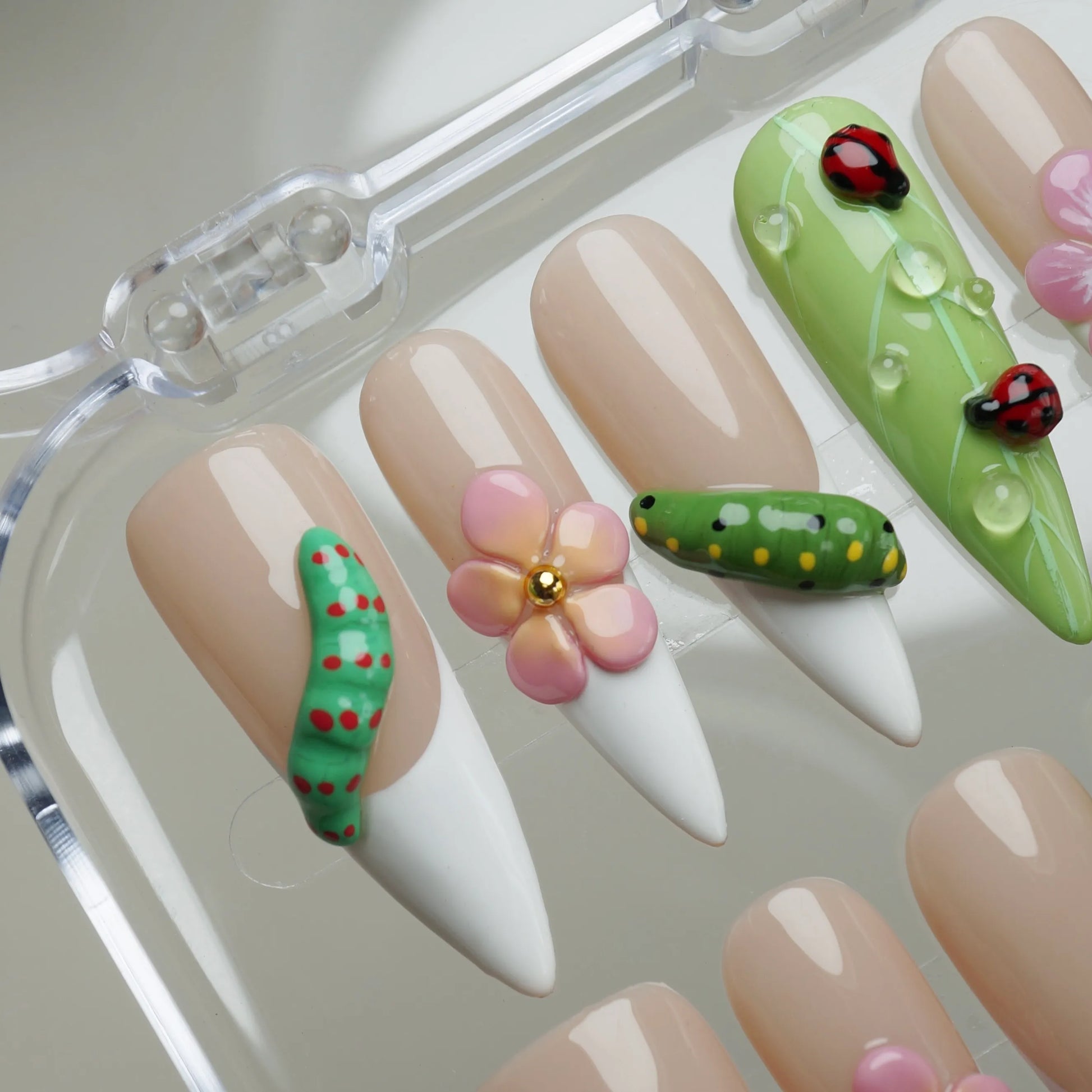 Mini Bug close-up detail featuring 3D caterpillar and ladybug accents with tiny flower designs on nude nails – Donailsart