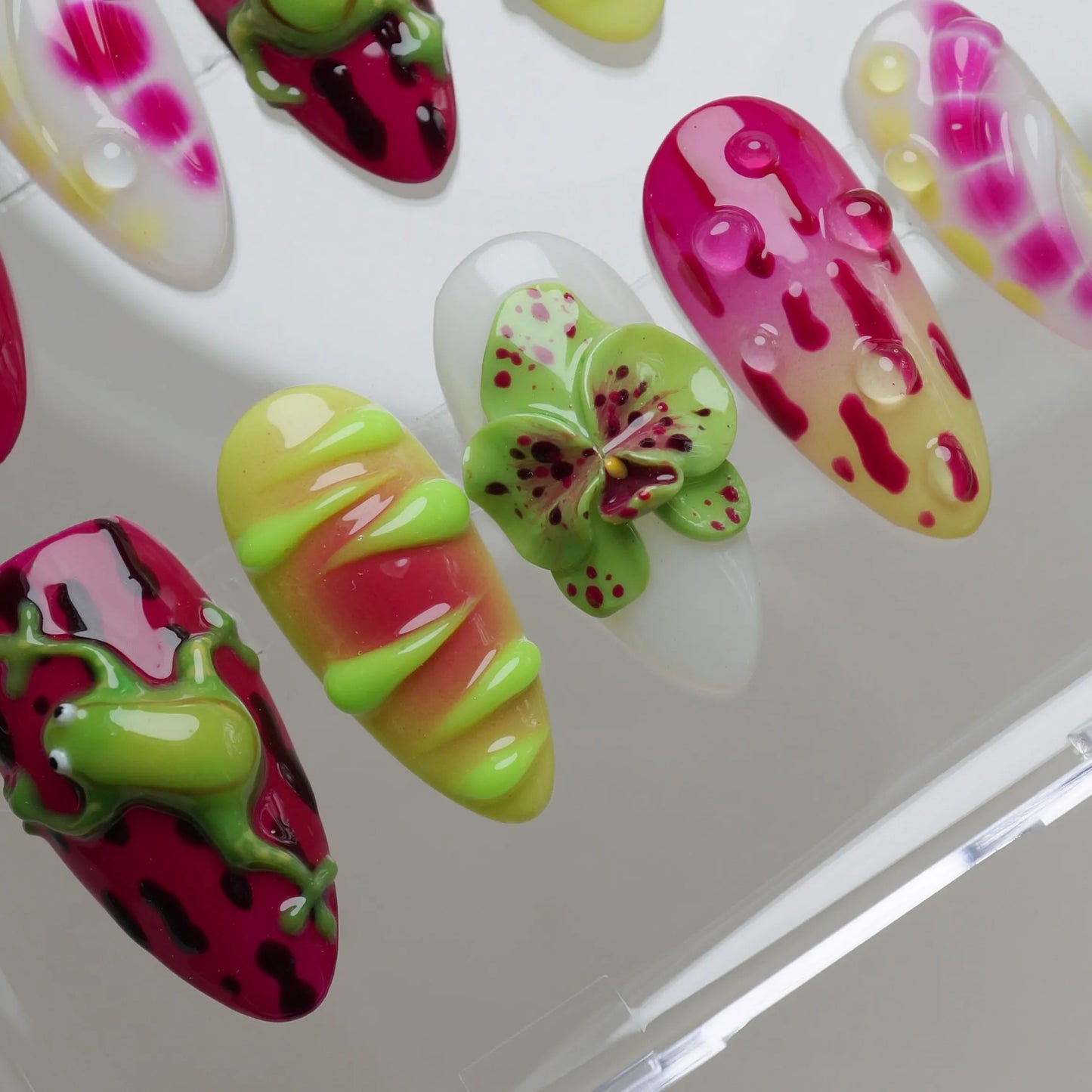 Colorful butterfly-shaped nail art designs on a white background