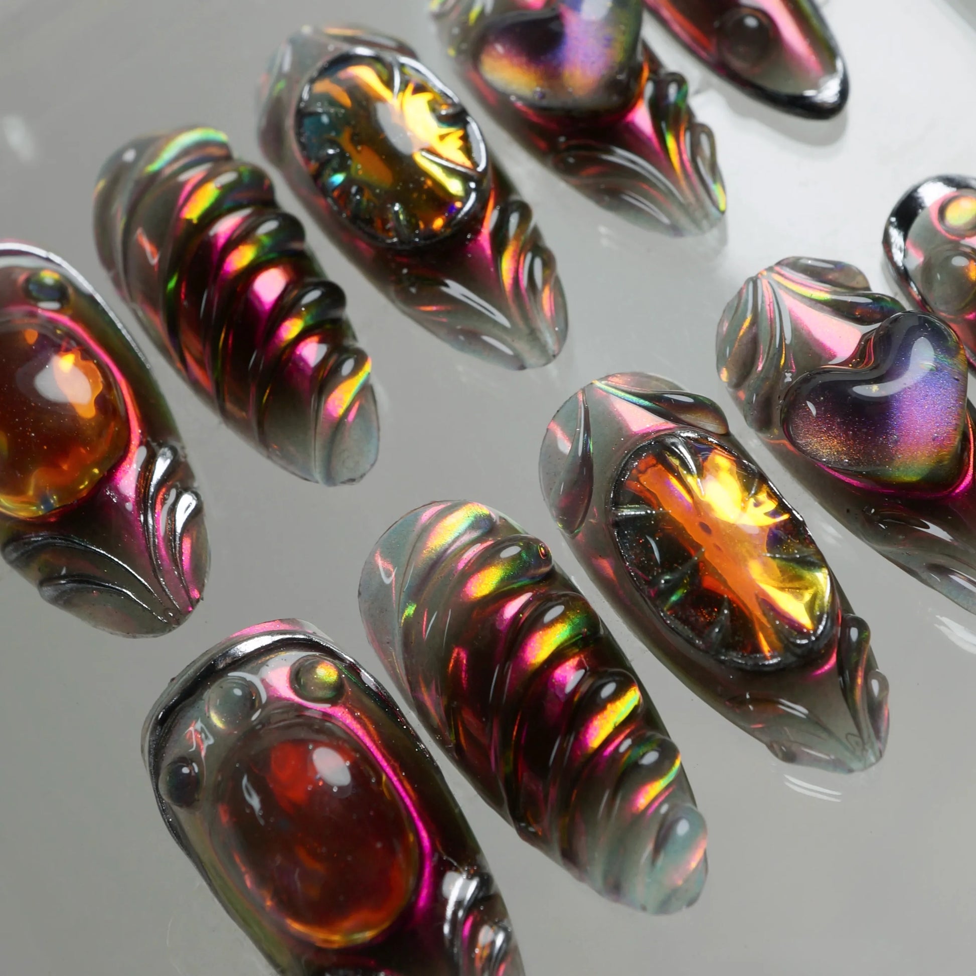 Donailsart press-on nails with black chrome armor style, fiery orange stones, and holographic finishes