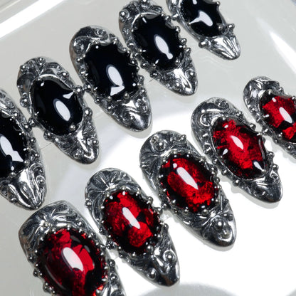 Gothic press-on nails with metallic sculpted frames, gemstone textures, and dark vampire-inspired palette
