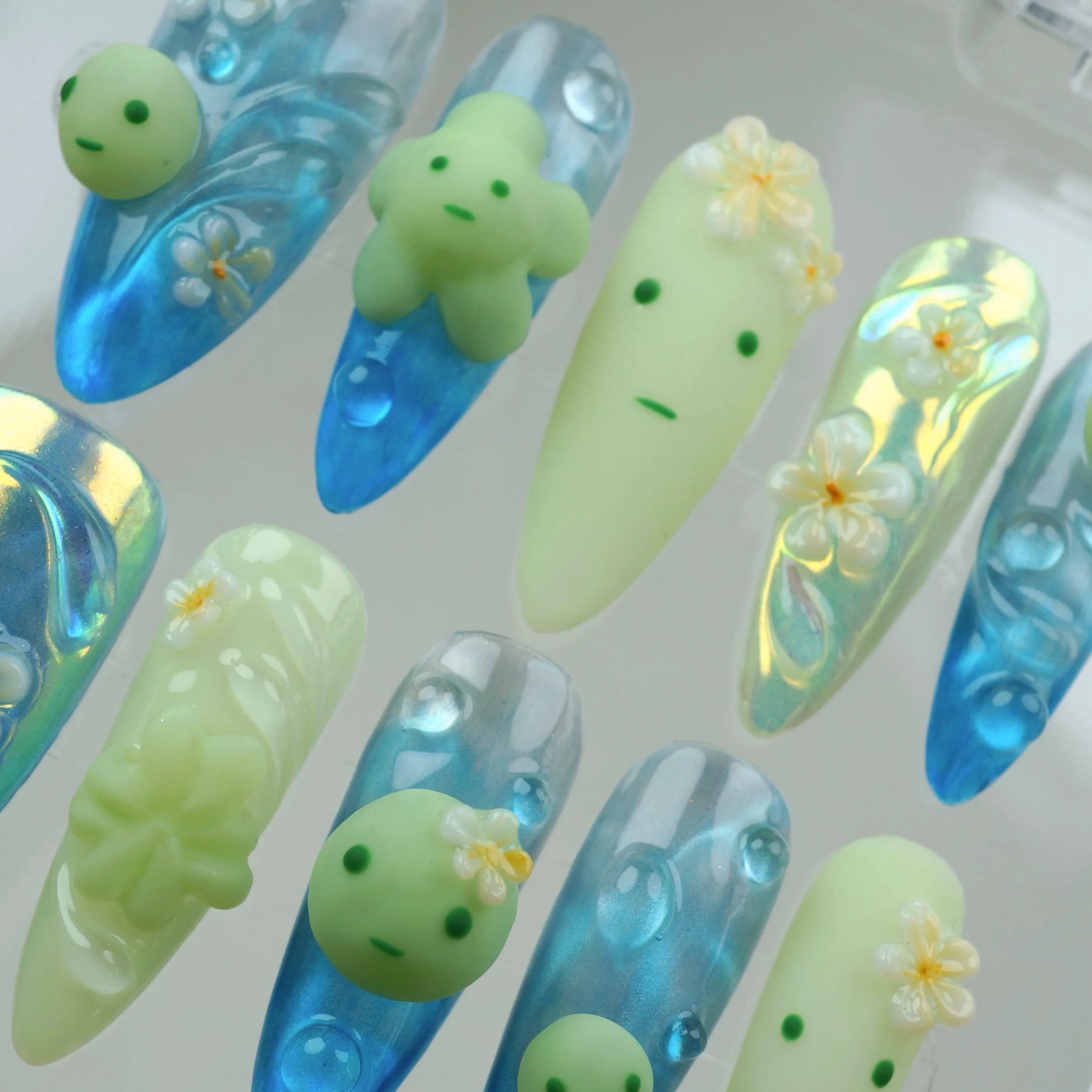 Fun smiski nails inspired by tiny glow characters, paired with clear aqua tones and beachy flower details