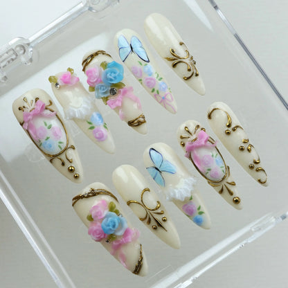 Whimsical birthday nails with 3D florals, delicate lace details, and vintage-inspired gold accents